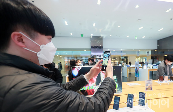 삼성전자가 올해 첫 스마트폰 갤럭시S22 시리즈를 공개한 10일 서울 서초구 삼성 딜라이트샵을 방문한 시민이 제품 카메라 성능을 확인하고 있다.