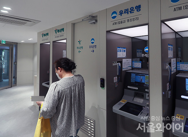 우리ㆍ 하나은행 공동점포를 찾은 시민이 은행업무를 보고 있다. 사진=서울와이어DB