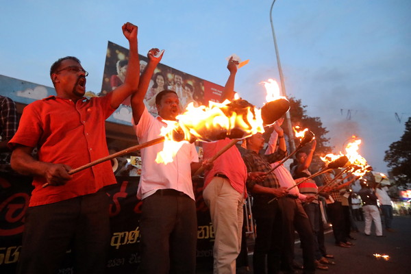 5일(현지시간) 스리랑카 수도 콜롬보에서 시위대가 횃불을 들고 경제위기를 규탄하는 구호를 외치고 있다. 스리랑카는 달러 고갈로 심각한 경제위기에 직면하면서 3개월 넘게 시위가 계속되고 있다 (사진  연합뉴스 제공)