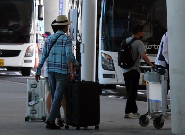 대한항공 기체 결함으로 임시 항공편를 타고 귀국한 승객들이 11일 오전 인천공항에서 항공사가 마련한 버스로 이동하고 있다. 사진=연합뉴스 제공