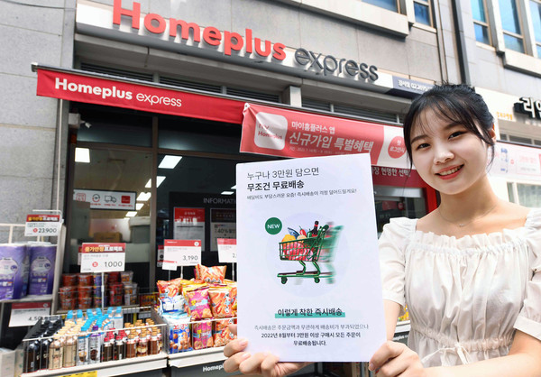 모델이 서울 화곡동 홈플러스 익스프레스 강서점에서 홈플러스 익스프레스 온라인 ‘1시간 즉시배송’ 서비스의 배송비 정책 변경을 안내하고 있다. 사진=홈플러스 제공