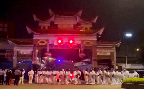 지난달 29일 광저우의 한 거리에서 흰 방호복을 입은 폭동진압 경찰이 시위를 진압하기 위해 진입하고 있다 (로이터=연합뉴스)