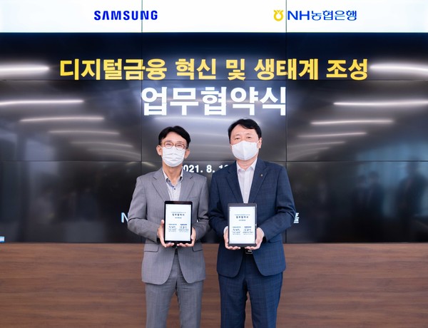  18일 서울 서초구 소재 NH디지털혁신캠퍼스에서 NH농협은행 권준학 은행장(사진 오른쪽)과 삼성전자 강봉구 한국총괄 부사장이 「디지털금융 혁신 및 생태계 조성을 위한 업무협약」을 체결하고 기념촬영을 하고 있다. 사진=농협은행 제공