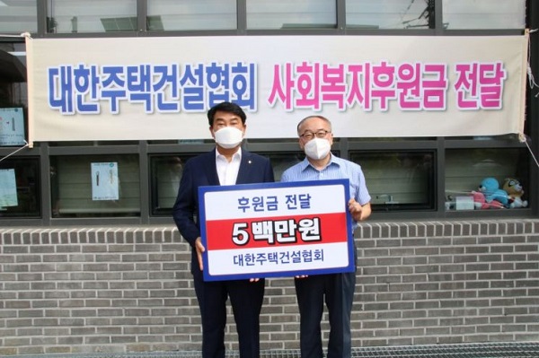 박재홍 대한주택건설협회 회장이 김광빈 동명아동복지센터 원장에게 후원금을 전달하고 있다. 사진=대한주택건설협회 제공