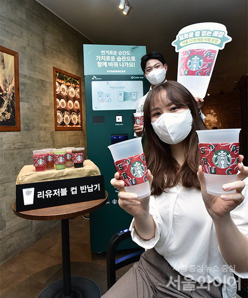스타벅스코리아가 오는 6일부터 제주지역에 이어 서울지역에서도 '일회용컵 없는 매장' 시범 운영 돌입에 앞서 5일 서울 중구 세종대로 한국프레스센터점에서 관계자들이 리유저블 컵(다회용컵) 반납기 앞에서 본 행사 취지를 알리는 플랜카드를 들고 있다.일회용컵 없는 매장은 스타벅스가 지난 4월 발표한 지속 가능성 중장기 전략인 'Better Together' 전략 일환으로 일회용컵 사용률 0%에 도전, 탄소 배출량을 감축하고자 기획, 내년중 서울 전 매장, 2025년에는 전국 모든 매장을 일회용컵 없는 매장으로 전환해 매장내 일회용컵 사용을 전면 중단할 계획으로 알려졌다.