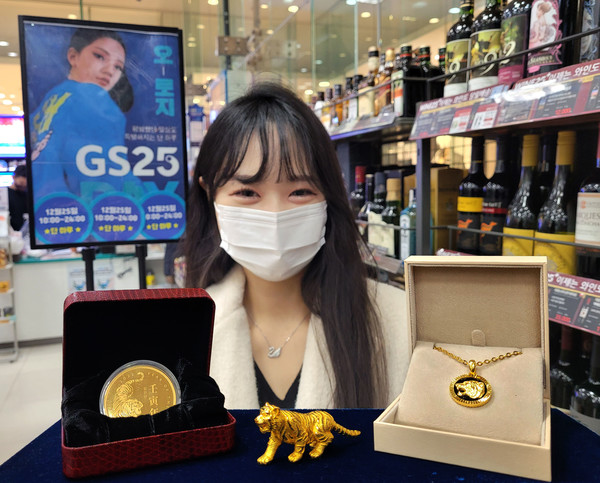 모델이 GS25 매장에서 임인년 호랑이 해 관련 금 상품을 들고 있다. 사진=GS리테일 제공