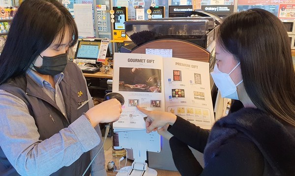 고객이 이마트24 매장에서 설 선물 카탈로그를 보며 주문하고 있다. 사진=이마트24 제공