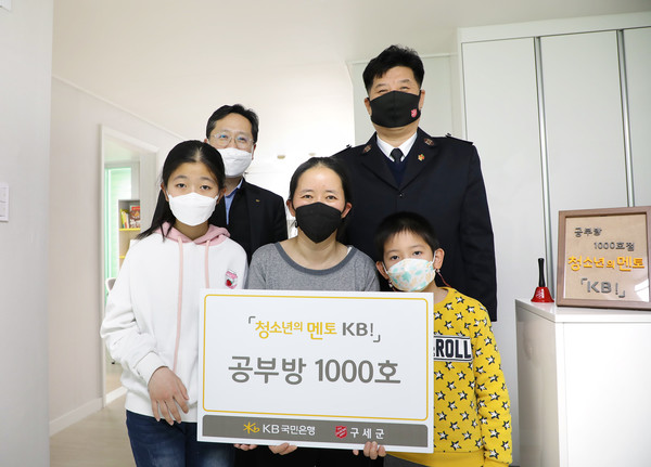 29일 경기도 시흥시에서 열린 '청소년의 멘토 KB!' 공부방 1000호 전달식에서 조용범(뒷줄 왼쪽) KB국민은행 ESG기획부장과 황규홍(뒷줄 오른쪽) 구세군자선냄비 업무국장이 수혜 가정 가족들과 기념사진을 찍고 있다. 사진=KB국민은행