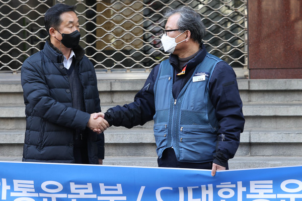 3일 오후 서울 중구 CJ대한통운 본사 앞에서 열린 CJ대한통운택배대리점연합과 전국택배노조 긴급 공동 기자회견에서 김종철 CJ대한통운택배대리점연합회장(왼쪽)과 진경호 택배노조 위원장이 악수하고 있다. 사진=연합뉴스 제공