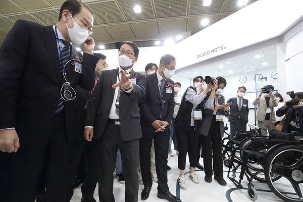 WIS 2022 KT 전시관에서 구현모 KT 대표(왼쪽 둘째) 가 권영세 대통령직인수위원회  부위원장(왼쪽 첫째)에게 AIoT 전동 휠체어를 설명하고 있다. 사진=KT 제공