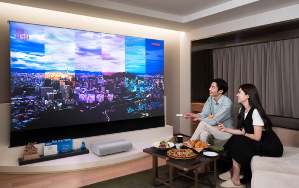 서울 광장동에 워커힐 호텔앤리조트 내 '시네마 스위트 with 삼성 더 프리미어' 객실에서 삼성 모델들이 프리미엄 빔 프로젝터 '더 프리미어'와 전용 롤러블 스크린을 체험하고 있다. 사진=삼성전자 제공