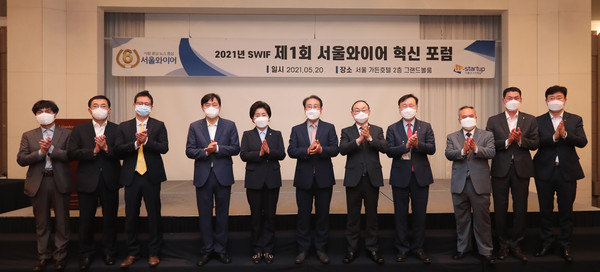 현형식 서울와이어 대표(가운데)와 국회, 금융당국, 산업·금융계 관계자들이 지난해 5월20일 오전 서울 마포구 소재 서울 가든호텔에서 열린 2021년 SWIF 제1회 서울와이어 혁신 포럼에 참석해 단체사진을 찍고 있다. 사진=이태구 기자