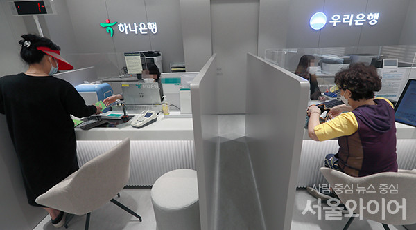 우리ㆍ 하나은행 공동점포를 찾은 시민이 은행업무를 보고 있다. 사진=서울와이어 DB