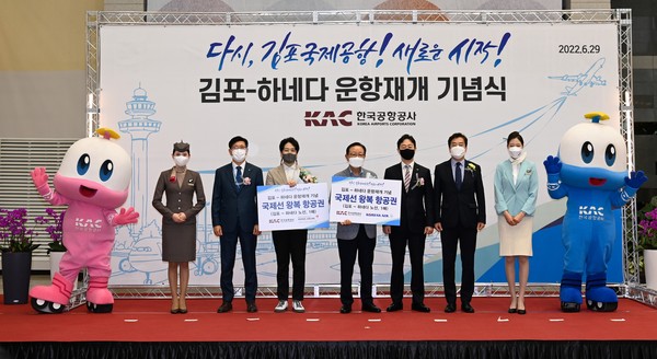 윤형중 한국공항공사 사장(왼쪽 5번째)이 김포-하네다 노선 첫 출발고객에게 왕복항공권을 증정하고 기념사진을 촬영하고 있다. 사진=한국공항공사 제공