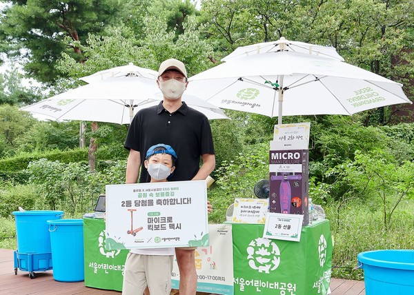 풀무원재단과 서울어린이대공원의 '보물줍깅' 캠페인에 참여한 어린이와 학부모가 보물을 찾아낸 후 기념 촬영을 하고 있다. 사진=풀무원 제공