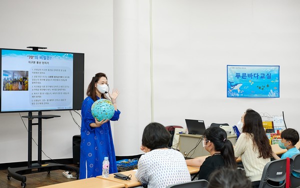 서울어린이대공원에서 개최한 풀무원재단 '푸른바다교실'에 참여한 어린이와 학부모가 집중해서 환경보호 이론 교육을 받고 있다. 사진=풀무원 제공