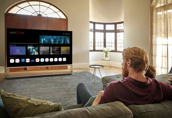 LG전자 모델이 webOS Hub가 탑재된 스마트 TV를 시청하고 있다. 사진=LG전자 제공