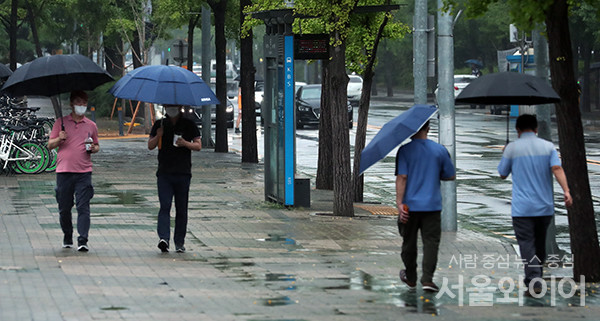 비내리는 24일 오후 서울 영등포구  여의도 거리에 시민들이 우산을 쓰고 이동하고 있다.
