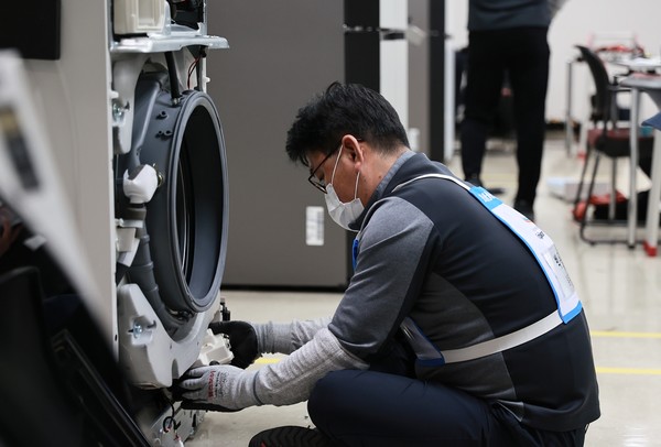 경기도 수원 삼성전자 CS아카데미에서 열린 제27회 서비스 기술경진대회에 참가한 엔지니어가 평가 종목 중 하나인 수리기술 경진에서 가전제품 결함을 고치고 있다. 사진=삼성전자서비스 제공 