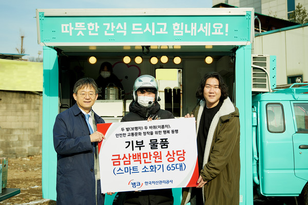 26일 경기도 성남시 하대원동 소재 국유지에서 열린 '유휴 국유지를 활용한 푸드트럭 음식 나눔 행사'에서 김동현 캠코 국유재산기획처장(왼쪽)이 기부 물품을 전달하고 기념촬영을 하고 있다. / 사진=캠코