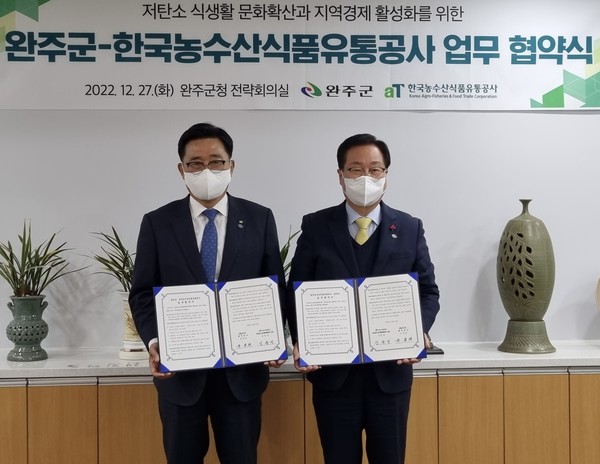 김춘진 aT 사장(왼쪽)과 유희태 완주군수가 27일 완주군청에서 저탄소 식생활 문화확산과 지역경제 활성화를 위한 업무협약식을 가진 뒤 기념촬영을 하고 있다. 사진=aT 제공