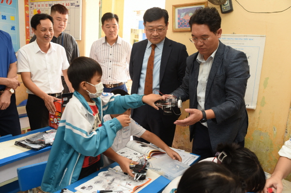 지난해 11월 진행된 LS드림스쿨 IT교실에서 LS메탈 정혁 법인장(가운데)과 코피온 김재철 지부장(오른쪽)이 로봇 코딩 클래스 교육을 참관하고 있다. 사진=LS그룹 제공