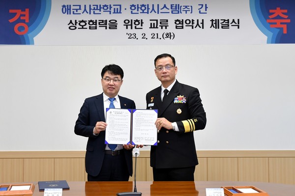 김영호 한화시스템 지휘통제사업부문장(왼쪽)과 황선우 해군사관학교장(중장)이 21일 경상남도 창원 소재 해군사관학교 교정에서 국방 및 해양 신사업 연구개발을 위한 산학협력 업무협약을 맺고 기념사진을 촬영하고 있다. 사진=한화시스템 제공