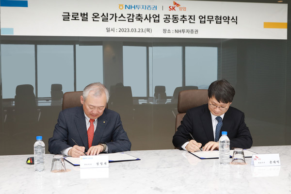 24일 NH투자증권 정영채 사장(좌측)과 SK임업 손대익 대표이사가 '글로벌 온실가스감축사업 공동추진'을 위한 업무협약서에 사인하고 있다. (사진=NH투자증권)
