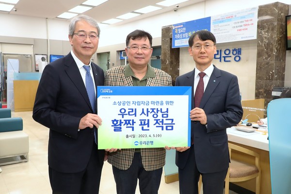 우리금융그룹 임종룡 회장(왼쪽)과 우리은행 정연기 중소기업그룹 부행장(오른쪽)이 소상공인 상생금융상품 '우리 사장님 활짝 핀 적금' 1호 가입 고객과 기념촬영을 하고 있다. (사진=우리금융)