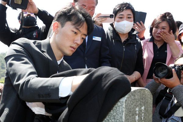 고(故) 전두환 전 대통령의의 손자 전우원 씨가 지난달 31일 오전 광주 북구 운정동 국립 5·18민주묘지를 찾아 무명열사 묘비의 먼지를 옷으로 닦고 있다(사진, 연합뉴스 제공)