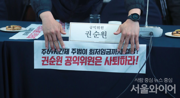 18일 서울 중구 프레스센터에서 '제1차 최저임금위원회' 전원회의 파행된 가운데 양대 노총 산하기관 관계자가 권순원 공익위원 사퇴를 촉구하는피켓을 붙이고 있다