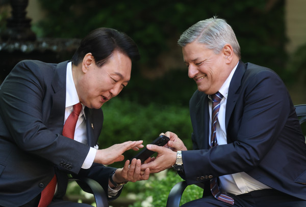 미국을 국빈 방문한 윤석열 대통령이 24일(현지시간) 워싱턴DC 백악관 영빈관 접견장에서 열린 글로벌기업 최고 경영진 접견에서 테드 서랜도스 넷플릭스 공동 최고경영자의 반려견 영상을 보며 즐거워하고 있다. (사진 연합뉴스 제공)