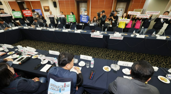 지난달 18일 오후 서울 중구 한국프레스센터에서 열린 최저임금위원회 제1차 전원회의에 앞서 한국노총, 민주노총 관계자들이 권순원 공익위원의 사퇴를 촉구하는 손팻말을 들고 있다. 사진=연합뉴스