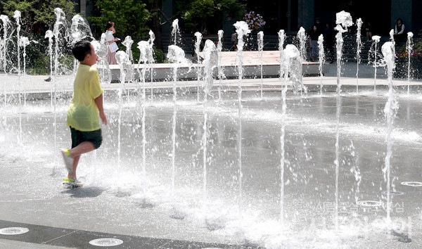 서울 광화문 광장을 찾은 시민이 물놀이를 하고 있다. 사진=서울와이어 DB