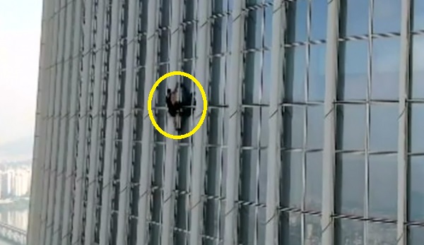 외국인 남성이 12일 오전 서울 잠실 롯데월드타워를 맨손으로 등반하고 있다. 사진=송파소방서 제공