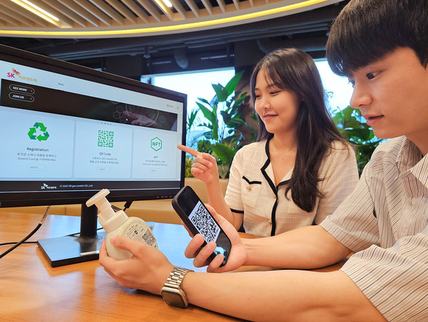 SK지오센트릭 구성원들이 QR코드로 블록체인 기반 플라스틱 리사이클(재활용) 소재 이력 플랫폼에 접속해 플라스틱 소재 정보를 확인하고 있다. 사진=SK지오센트릭 제공