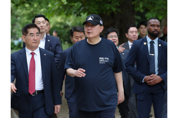 윤석열 대통령이 천안함 로고가 새겨진 티셔츠와 모자를 쓰고 산책을 하고 있다. 사진=연합뉴스 제공