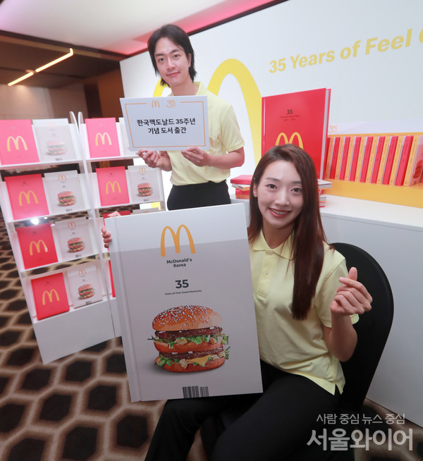 모델들이 도서 모형을 들고 있다.