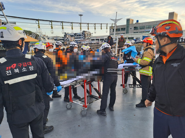 전북 부안군의 한 항구에서 낚시어선 전복 사고를 당한 승선원들을 소방당국이 병원으로 이송하고 있다. 사진=연합뉴스