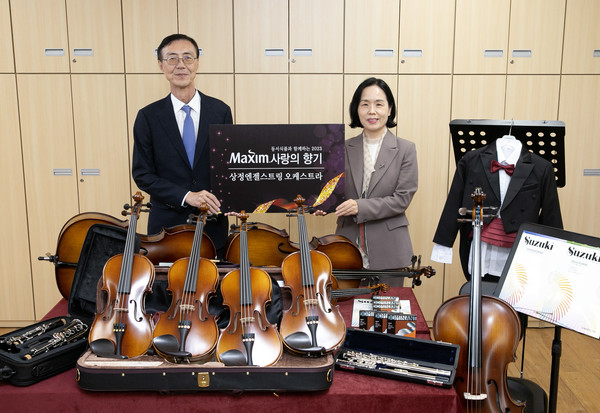최상인 동서식품 홍보상무(왼쪽)와 이숙경 인천상정초등학교  교장이 20일 인천상정초등학교에서 진행된 ‘제16회 맥심 사랑의 향기’ 악기 기증식을 가진 뒤 기념촬영을 하고 있다. 사진=동서식품 제공