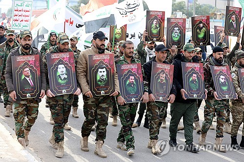 이라크에서 활동하는 친 이란 무장단체 조직원들이 최근 미군의 공습으로 사망한 동료들의 장례식에서 영정을 들고 행진하고 있다.(EPA=연합뉴스)