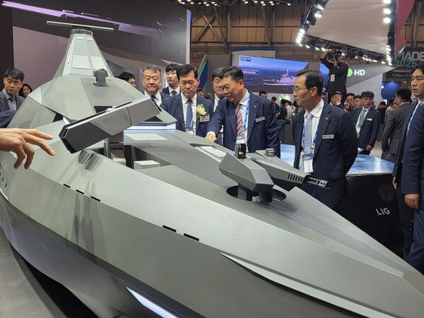 LIG넥스원이 국제해양방위산업전 2025(MADEX)에서 미래 무인수상정인 '해검-X'를 공개했다. 신익현 LIG넥스원 대표이사(오른쪽)와 석종건 방위사업청장(코사지 착용), 신용화 LIG넥스원 미래전장사업본부장이 해검-X관련 대화를 나누고 있다. 사진=LIG넥스원