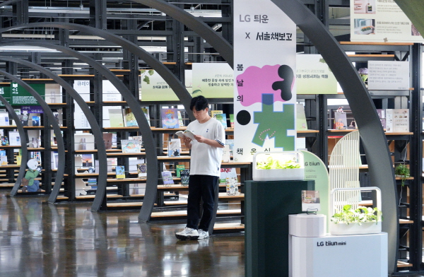 LG전자가 내달 13일까지 서울 송파구에 있는 ‘서울책보고’에서 식물생활가전 ‘LG 틔운 미니’를 활용해 식물과 독서가 만나는 특별한 체험 공간을 선보인다. 사진은 LG 틔운 미니를 활용해 조성된 내부 서가와 열람실 공간에서 독서하며 다양한 식물을 감상하는 모습. 사진=LG전자 제공