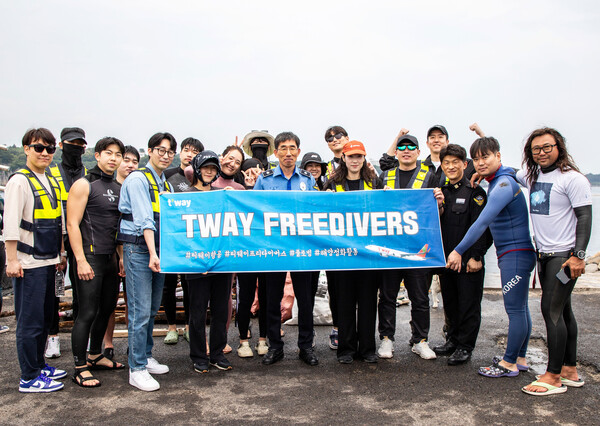 지난달말 제주도 서귀포항 해안가에서 진행된 해양정화 활동 후 티웨이항공 프리다이버스와 박상춘 제주지방해양경찰청장(가운데), 전장원 플로빙코리아 대표(오른쪽 첫 번째)가 기념 사진을 촬영하고 있다. 사진=티웨이항공