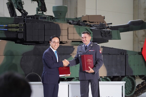 지난 1일 폴란드 글리비체에서 열린 K2 전차 2차 이행계약 서명식에서 이용배 현대로템 사장(왼쪽)과 아르투르 쿱텔 폴란드 군비청장이 이행계약서에 서명 후 악수하고 있다. 사진=연합뉴스