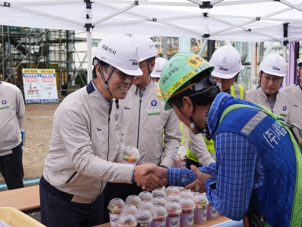 이용배(왼쪽) 현대로템 사장이 14일 당진제철소 내에 위치한 3코크스 건식소화설비(CDQ) 건설현장에 마련된 빙수차 앞에서 근로자들에게 컵빙수를 전달하고 있다. 사진=현대로템
