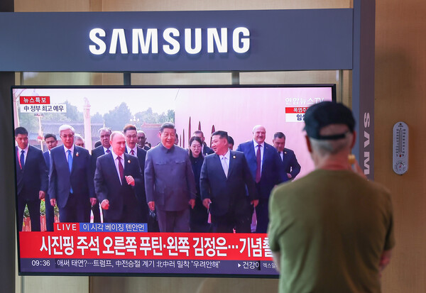 중국 베이징 톈안먼 광장에서 ‘항일전쟁 및 세계 반파시스트 전쟁 승전’(전승절) 80주년 열병식에 앞서 시진핑(가운데) 중국 국가주석과 블라디미르 푸틴 러시아 대통령, 김정은 북한 국무위원장과 함께 걸으며 입장 중읻. 해당 장면이 서울역 대합실 TV에서 나오고 있다. 사진=연합뉴스