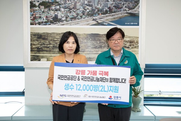 5일 국민연금공단에서 진행한 생수 긴급 지원 기부식에서 이여규 국민연금공단 복지이사와 김동율 강릉시 행정국장이 기념 촬영을 하는 모습. 사진=국민연금공단 제공