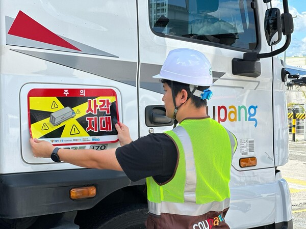 쿠팡·쿠팡로지스틱스서비스 대형 화물차에 사각지대 주의 알림 표지를 부착하는 모습. 사진=쿠팡 제공