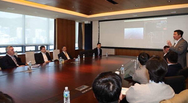 폴 르윈 해벅AI(HavocAI) CEO(맨 오른쪽)가 한화 임직원들에게 하와이 앞 바다에 대기 중인 해벅AI의 무인수상정을 한화오션 거제사업장에서 원격 통제하는 기술 시연을 선보이고 있다. 사진=한화시스템